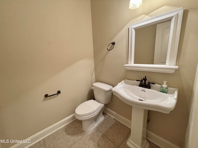 bathroom with toilet and tile patterned flooring