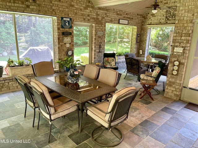 dining area with brick wall, ceiling fan, and plenty of natural light