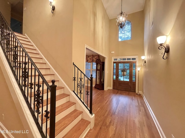 foyer with a chandelier, hardwood / wood-style floors, and high vaulted ceiling