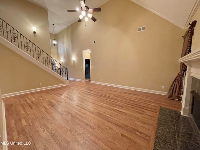 unfurnished living room with wood-type flooring, high vaulted ceiling, and ceiling fan