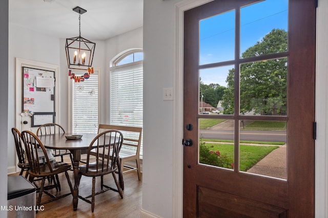 dining area featuring a chandelier, baseboards, and wood finished floors