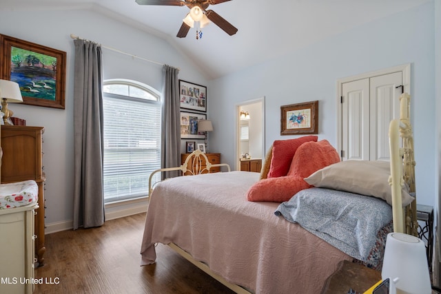 bedroom featuring lofted ceiling, multiple windows, wood finished floors, baseboards, and ceiling fan