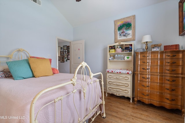 bedroom with vaulted ceiling and wood finished floors