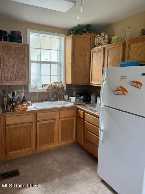 kitchen with sink, tasteful backsplash, and white refrigerator