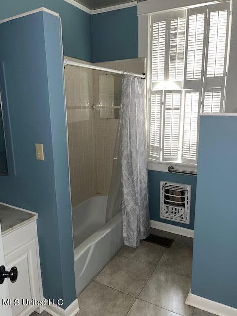 bathroom featuring shower / bath combo, tile patterned floors, heating unit, and plenty of natural light