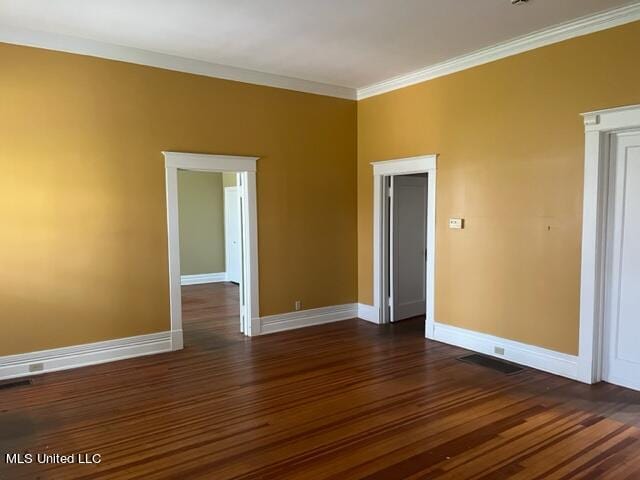 spare room with ornamental molding and dark hardwood / wood-style floors