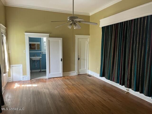 unfurnished bedroom featuring crown molding, ensuite bathroom, wood-type flooring, and ceiling fan