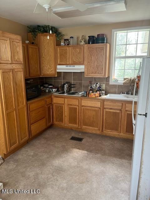 kitchen with sink, ceiling fan, tasteful backsplash, and white refrigerator