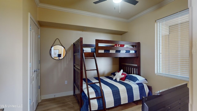 bedroom featuring hardwood / wood-style floors, crown molding, and ceiling fan