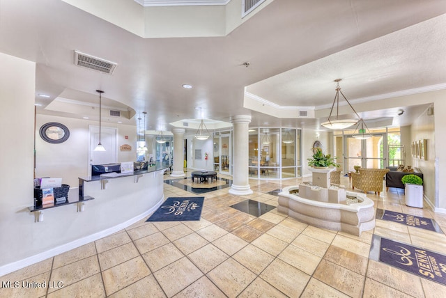 interior space with crown molding, decorative columns, and a tray ceiling