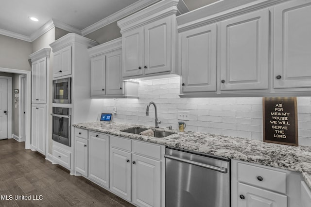 kitchen featuring stainless steel appliances, ornamental molding, a sink, and white cabinets