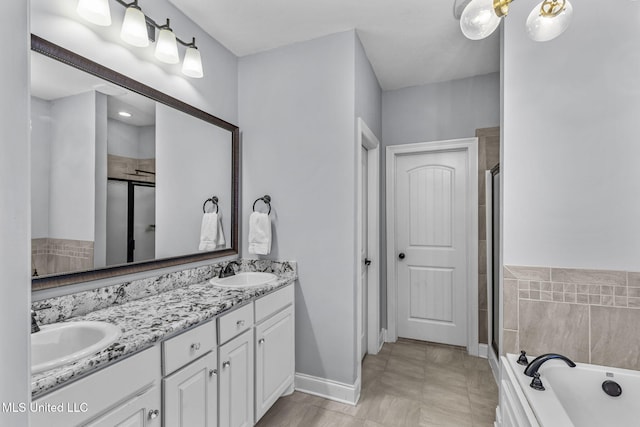 full bathroom featuring a tub, a sink, a shower stall, and double vanity