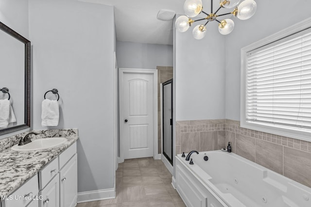 full bathroom featuring a chandelier, vanity, baseboards, a tub with jets, and a stall shower