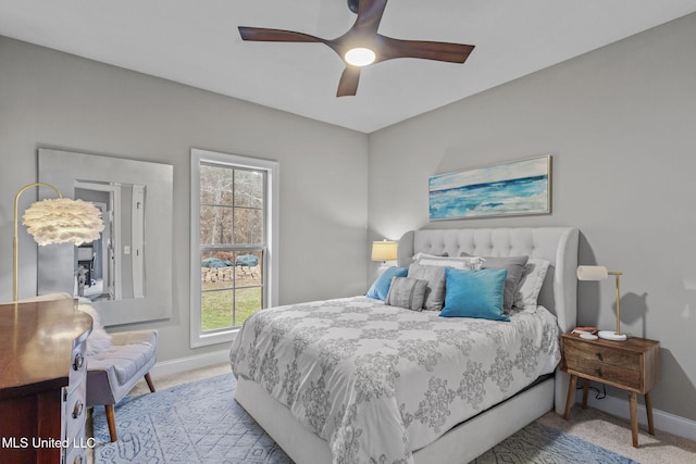 carpeted bedroom with ceiling fan and baseboards