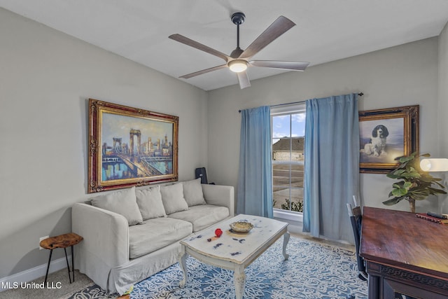 living room featuring baseboards, a ceiling fan, and carpet flooring