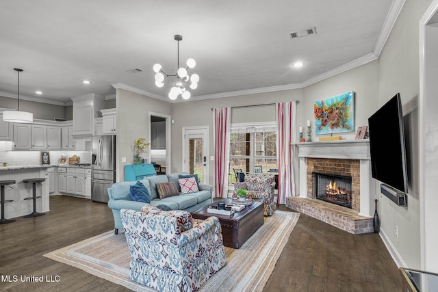 living area with dark wood-style flooring, crown molding, recessed lighting, visible vents, and a brick fireplace