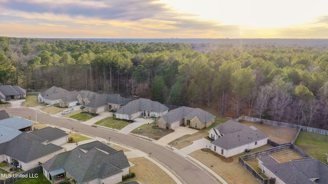 aerial view at dusk with a forest view and a residential view