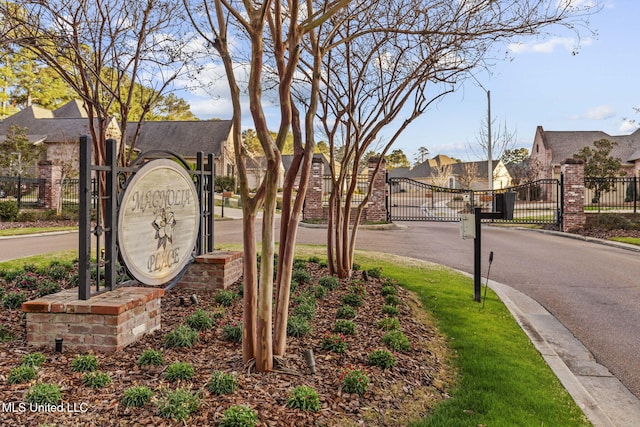 view of road with a residential view, a gate, a gated entry, and curbs