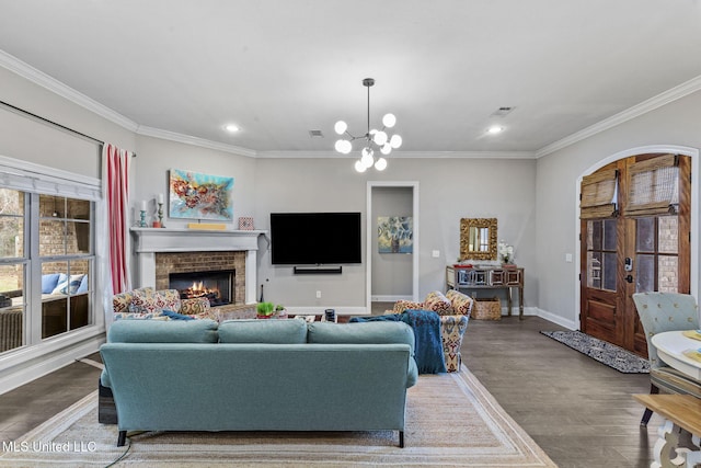 living room featuring arched walkways, ornamental molding, wood finished floors, and an inviting chandelier