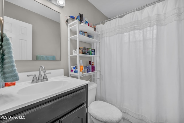 bathroom with toilet, vanity, and a shower with shower curtain