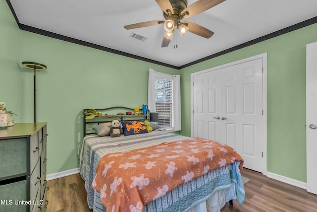 bedroom featuring ceiling fan, hardwood / wood-style flooring, a closet, and crown molding