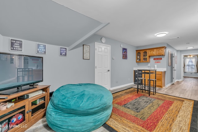 living room with bar and light hardwood / wood-style flooring