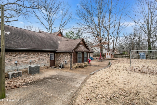 view of property exterior featuring cooling unit, a storage shed, and a patio