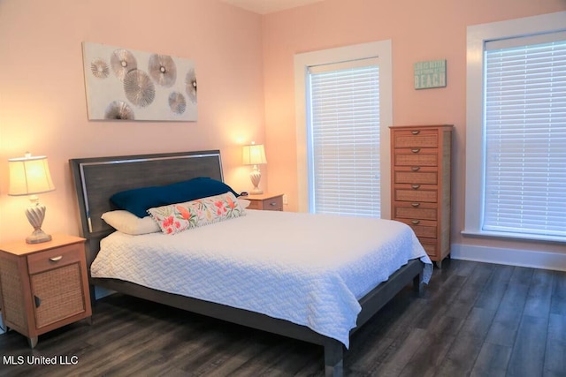 bedroom with dark wood-style flooring and baseboards