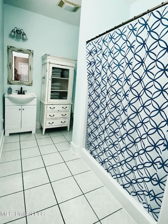 bathroom with tile patterned flooring, vanity, visible vents, and a shower stall