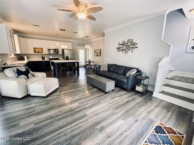 living room with baseboards, a ceiling fan, stairway, wood finished floors, and crown molding