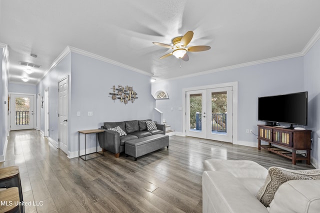 living area featuring wood finished floors, visible vents, french doors, stairway, and crown molding