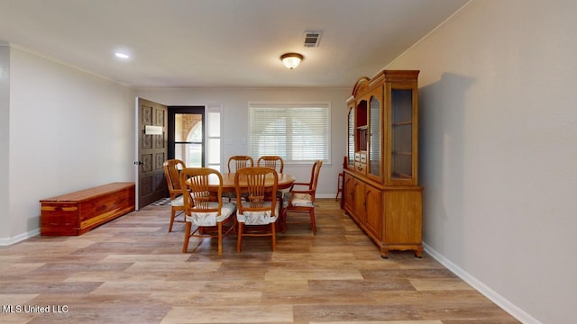 dining area with light hardwood / wood-style floors and crown molding