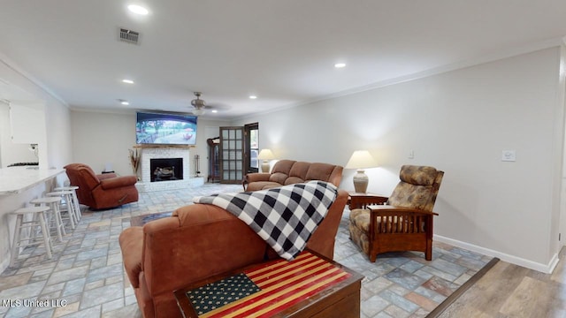 living room with ornamental molding, light wood-type flooring, and ceiling fan