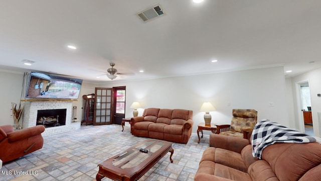 living room featuring crown molding, a fireplace, and ceiling fan