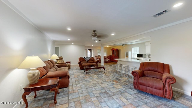 living room featuring ornamental molding and ceiling fan