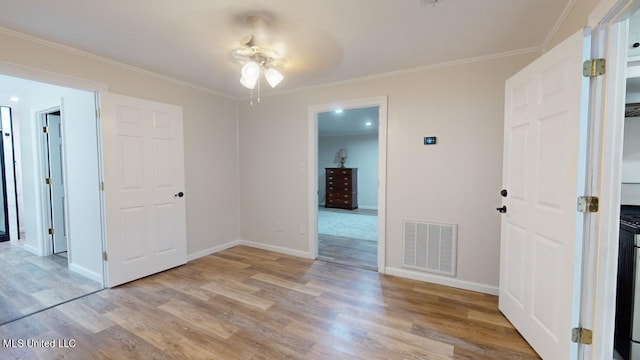 unfurnished room featuring light hardwood / wood-style floors, crown molding, and ceiling fan