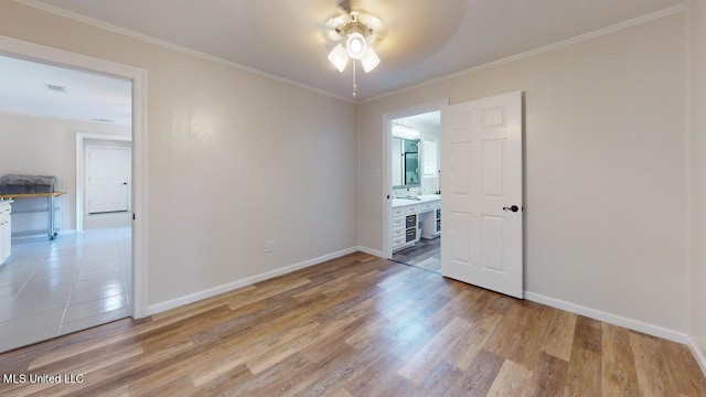 unfurnished room featuring ornamental molding, light wood-type flooring, and ceiling fan