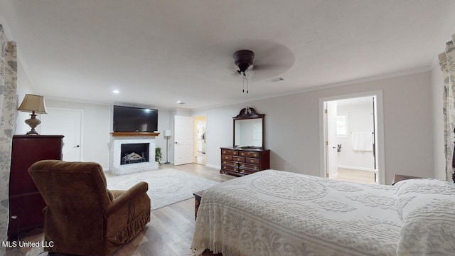 bedroom with ornamental molding, ceiling fan, light hardwood / wood-style floors, and ensuite bath