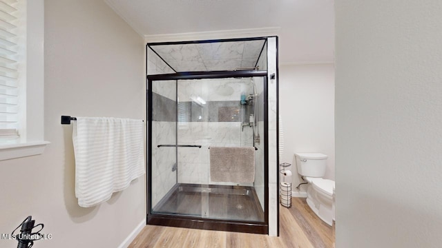 bathroom featuring toilet, crown molding, hardwood / wood-style floors, and walk in shower