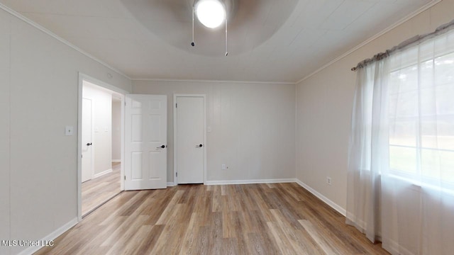 empty room featuring ornamental molding, light hardwood / wood-style floors, and ceiling fan