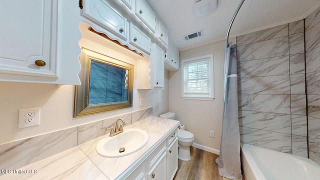 full bathroom with shower / bath combo, toilet, wood-type flooring, crown molding, and vanity