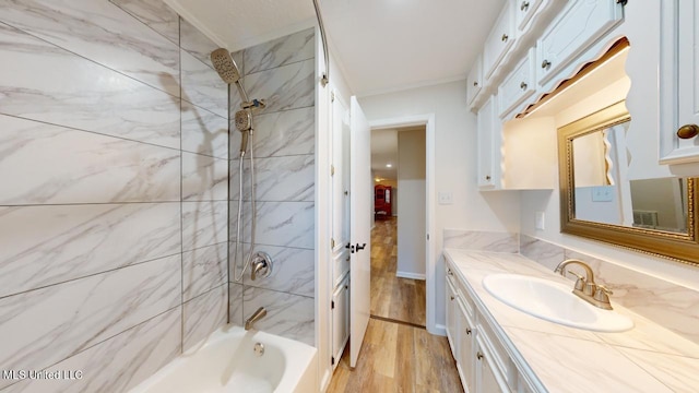 bathroom with vanity, hardwood / wood-style floors, and tiled shower / bath