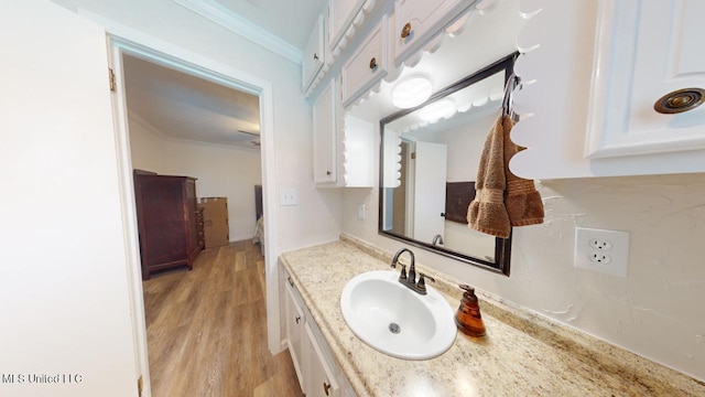 bathroom featuring vanity, crown molding, and wood-type flooring