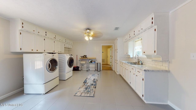 clothes washing area featuring sink, light tile patterned floors, washer and dryer, cabinets, and ceiling fan