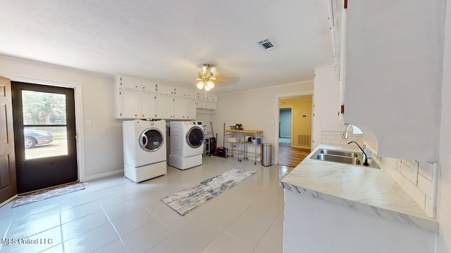 clothes washing area featuring sink, light tile patterned floors, washing machine and dryer, cabinets, and ceiling fan