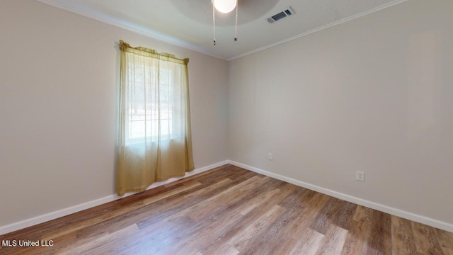 spare room featuring light hardwood / wood-style flooring, ornamental molding, and ceiling fan