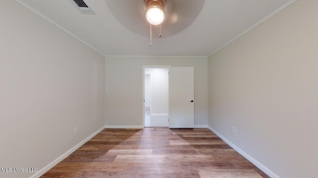 spare room featuring crown molding, light wood-type flooring, and ceiling fan