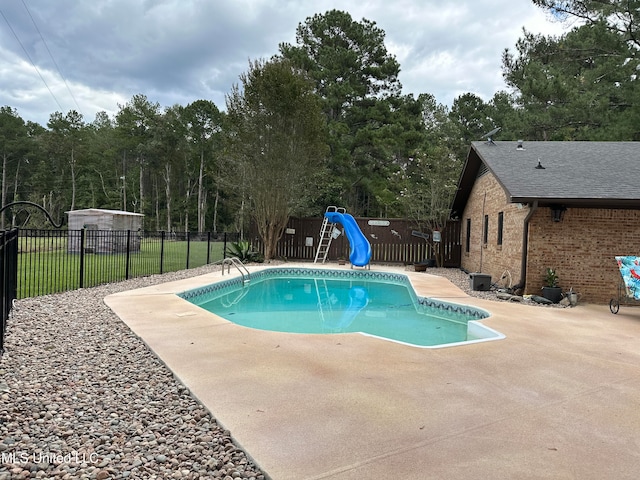 view of swimming pool with a patio and a water slide