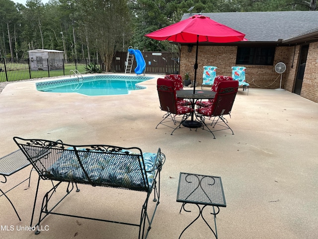 view of swimming pool featuring a water slide and a patio