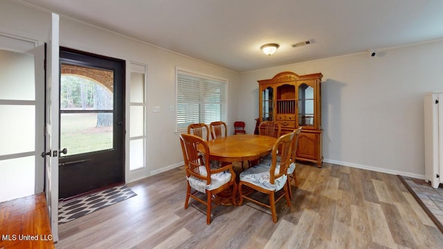 dining area featuring crown molding and light wood-type flooring